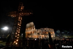 Prosesi Jalan Salib dalam peringatan Jumat Agung di Koloseum, Vatikan, Jumat, 7 April 2023. Paus Fransiskus tidak hadir dalam acara itu dan menyaksikan prosesi dari Casa Santa Marta di Vatikan karena cuaca dingin. (Foto: Vatican Media via Reuters)