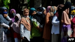 Sejumlah perempuan antre membeli sembako murah di Banda Aceh, 14 Mei 2020. Pemerintah Provinsi Aceh, Kamis (10/8), menerapkan aturan yang mengharuskan laki-laki dan perempuan yang tidak memiliki hubungan langsung atau menikah, terpisah di kendaraan dan tempat umum. (Foto: AFP)
