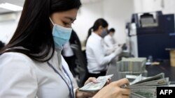 រូបឯកសារ៖ បុគ្គលិកធនាគារអេស៊ីលីដា រាប់ក្រដាស់ប្រាក់ដុល្លារ នៅក្នុងទីស្នាក់ការធនាគារអេស៊ីលីដា នៅរាជធានីភ្នំពេញ កាលពីថ្ងៃទី២៥ ខែឧសភា ឆ្នាំ២០២០។ 