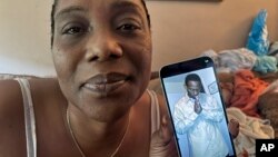 Anđela Lindzi drži fotografiju svog sina Brekstona Muna koji je poginuo (AP Photo/Robin McDowell)