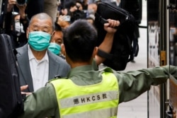 FILE - Democracy advocate Jimmy Lai, center, leaves the Hong Kong's Court of Final Appeal in Hong Kong, Feb. 9, 2021.