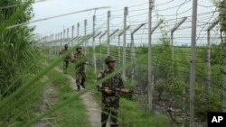 India’s Border Security Force soldiers patrol near the India-Pakistan international border fencing at Garkhal in Akhnoor, west of Jammu, India, Aug. 13, 2019. 