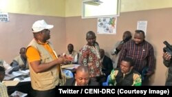 Le président de la CENI Corneille Nangaa, debout au milieu, fait le tour des bureaux de réception et de traitement des candidatures à Kinshasa, RDC, 8 juillet 2018. (Twitter/ CENI-RDC)