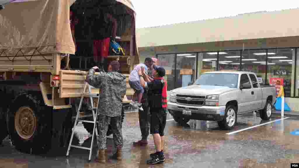 Trestian Woodard, 7, finds welcoming arms at a gas station doubling as a rescue transfer point in north Houston, Texas, Aug. 27, 2017. National Guard and Aldine Fire & Rescue members collected people from the Greenbriar Colony neighborhood. (C. Mendoza/VO