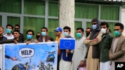 FILE - Former Afghan interpreters hold placards during a protest against the U.S. government and NATO in Kabul, Afghanistan, April 30, 2021.