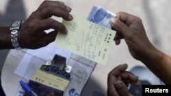 A man bets in a numbers game known as "game of animals" in Rio de Janeiro, Brazil, Sept. 22, 2015.
