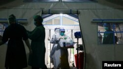 Perawat bersiap membantu pasien COVID-19 yang dirawat di tenda darurat sebuah rumah sakit di Jakarta, 24 Juni 2021. (REUTERS/Ajeng Dinar Ulfiana)