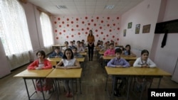 格鲁吉亚一名老师和她的5年级的学生2015年6月8日在首都第比利斯的一所公立小学里。