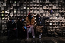 FILE - People take a selfie in a shopping mall in Wuhan, Hubei province, China, Jan. 22, 2021.