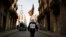 A man wearing a Guy Fawkes mask holds an Estelada, a Catalan pro-independence flag, as he walks towards a protest against a separatism-related police operation, in Barcelona, Spain, Oct. 28, 2020. His signs oreads "Enough repression. Independence."