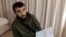 FILE - Chechen blogger Tumso Abdurakhmanov holds a letter from Interpol during an interview with The Associated Press somewhere in Poland, Nov. 14, 2018.