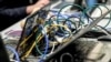 FILE - Wires are plugged into laptop computers as people work during the 11th International Cybersecurity Forum, January 22, 2019.