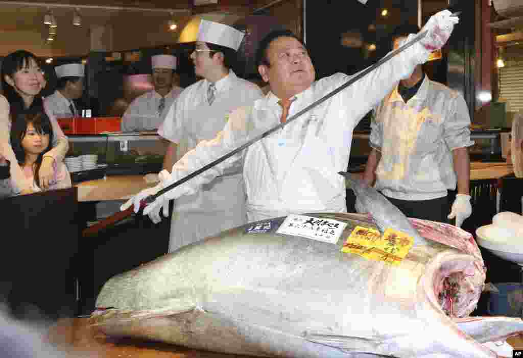 Kiyoshi Kimura, pemilik restoran sushi Sushi Zanmai, bersiap memotong ikan tuna seberat 181 kilogram di dekat pasar ikan Tsukiji, Tokyo, Jepang.