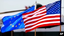 FILE - The U.S. and European Union flags wave at Dulles International Airport, Virginia, May 18, 2012.