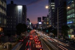 In this Oct. 12, 2020, file photo, streaks of lights from cars pass through a business district in Tokyo. Japan aims to eliminate gasoline-powered vehicles in about 15 years.