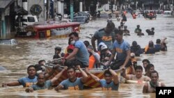Tim SAR mengevakuasi warga yang terdampak banjir akibat hantaman Topan Vamco di Kota Marikina, pinggiran kota Manila,12 November 2020. (Foto: Ted ALJIBE / AFP)
