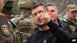 Presiden Ukraina Volodymyr Zelenskyy menunjuk kerusakan rudal saat berkunjung ke Zaporizhzhia, Ukraina, Senin, 27 Maret 2023. (Foto: AP)