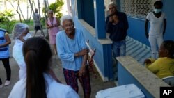 FILE - An elderly woman waits to get a dose of the Pfizer COVID-19 vaccine at Casa de Repouso Laco de Ouro nursing home, in Rio de Janeiro, Brazil, Sept. 2, 2021.