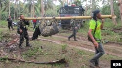 Filipino soldiers carry a recovered body in the town of Jolo, Sulu Island, southern Philippines, April 27, 2016. Authorities are working to confirm whether the headless corpse found on Jolo Island is that of Canadian hostage beheaded on April 25, 2016, by Islamist group Abu Sayyaf. 