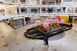 FILE - Shoppers walk past a Lunar New Year display at the Aberdeen Centre, which is named after the Aberdeen Harbour in Hong Kong, in Richmond, British Columbia, Jan. 26, 2021.