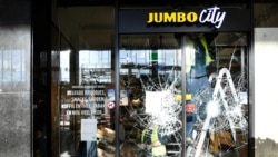 Glaziers remove broken glass at a supermarket after yesterday's riots against the COVID-19 lockdown in Eindhoven, Netherlands January 25, 2021. REUTERS/Piroschka van de Wouw