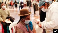 A woman gets a shot of the Sinopharm COVID-19 vaccine during vaccinations of people over age 40 inside the gym of the American Institute school in La Paz, Bolivia, June 4, 2021.