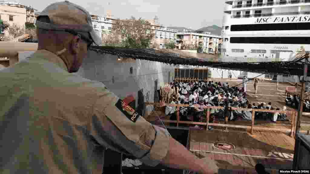 Un militaire norvégien regarde les migrants sur le navire &quot;Siem Pilot&quot; dans le port de Messine, Sicile, 6 octobre 2015 (Nicolas Pinault/VOA).