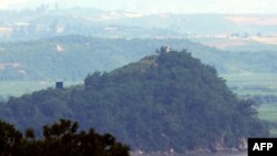 한국 경기도 파주시 오두산통일전망대에서 바라본 북한 황해도 개풍군 한 마을에 23일 대남 확성기가 설치돼 있다. 북한은 최전방지역에 대남 심리전 수단으로 재설치 작업을 벌였던 확성기 방송 시설을 사흘만에 모두 철거한 것으로 알려졌다. 