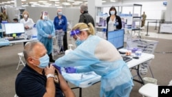 Sgt. Brian Patrick McKnerney of the New Jersey State Police receives a COVID-19 vaccination at the Morris County vaccination site in Rockaway, N.J., Jan. 8, 2021. 