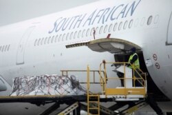 FILE - A worker looks on as the second delivery of the Johnson &amp; Johnson COVID-19 vaccine is offloaded at the O.R Tambo International Airport in Johannesburg, South Africa, Feb. 27, 2021.