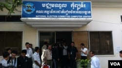 អ្នក​យក​ព័ត៌មាន​ចោមរោម​នៅ​មុខ​មជ្ឈមណ្ឌល​កុំព្យូទ័រ​បស់​គណៈកម្មាធិការ​ជាតិ​រៀប​ចំ​ការ​បោះឆ្នោត។