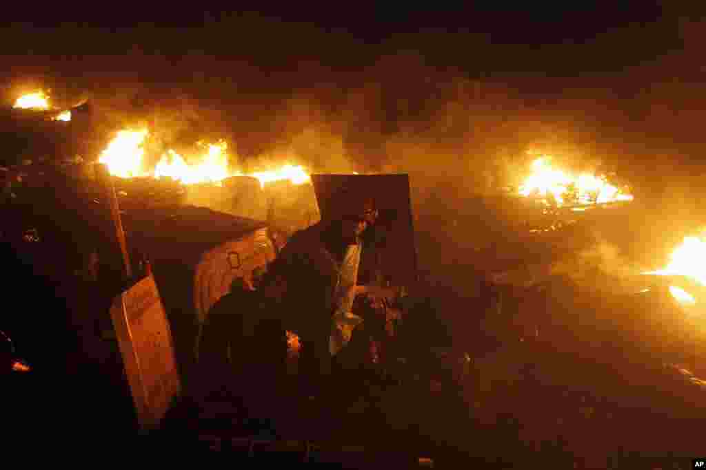 An anti-government protester prepares to throw a car tire into the flames lit by protesters, Independence Square, Kyiv, Feb. 20, 2014.