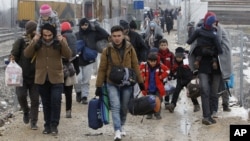People walk from the transit center for refugees towards the border with Serbia, near the northern Macedonian village of Tabanovce, Jan. 26, 2016.