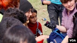 A volunteer paints the nails of refugees in Idomeni on the Greek-Macedonian border. (J. Dettmer/VOA)