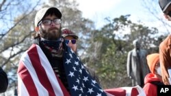Demonstrators stand in front of the South Carolina Statehouse, in Columbia, Jan. 17, 2021. 