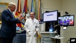 美国总统川普在白宫罗斯福室举行的退伍军人事务部“远程医疗服务”活动中在退伍军人事务部部长舒尔金的陪同下与一位患者交谈。（2017年8月3日）