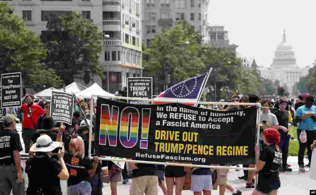Groups protest in Freedom Plaza with the U.S. Capitol in the background, on the one year anniversary of Charlottesville's "Unite the Right" rally, Sunday, Aug. 12, 2018, in Washington.