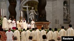 FILE - Pope Francis blesses a newly ordained priest during a mass in Saint Peter's Basilica at the Vatican, April 22, 2018.