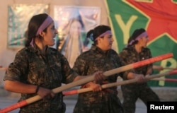 FILE - Kurdish female fighters of the Women's Protection Unit (YPJ) participate in training at a military camp in Ras al-Ain city in Syria's Hasakah province, June 30, 2014.
