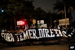 Demonstrators protest holding a banner that reads in Portuguese "Get out Temer, elections now," outside the residence of Brazil's President Michel Temer during a general strike in Sao Paulo, Brazil, April 28, 2017. Buses, trains and metros have been halted.