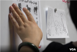 A teacher at Ana Care Education teaches Uyghur animal and color vocabulary.