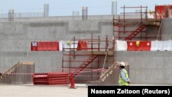 រូបឯកសារ៖ បុរស​ម្នាក់​ពិនិត្យ​មើល​ការដ្ឋាន​សំណង់​កីឡាដ្ឋាន Al Wakrah ដែល​ត្រូវ​បាន​រំពឹង​ថា នឹង​ប្រើ​ជា​កីឡាដ្ឋាន​សម្រាប់​ការ​ប្រកួត​បាល់ទាត់​ពិភពលោក​ឆ្នាំ ២០២២ នៅ​ប្រទេស​កាតា​ ក្នុង​ក្រុង Al Wakrah កាល​ពី​ថ្ងៃ​ទី១២ ខែ​មេសា ឆ្នាំ​២០១៦។