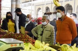 Residents wearing face masks shop for the Ramadan in Tunis, April 23, 2020.