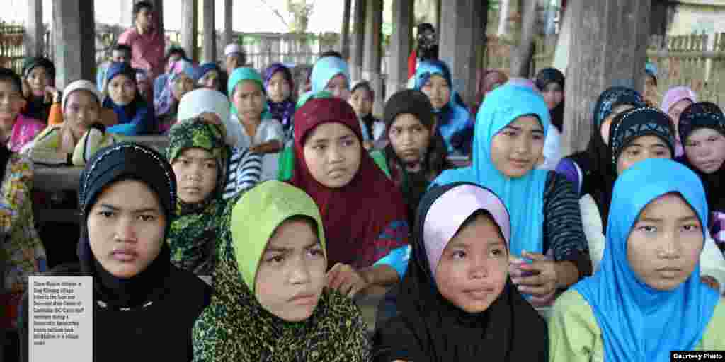 Cham Muslim children in Svay Khleang village listen to the Tuon and Documentation Center of Cambodia (DC-Cam) staff members during a Democratic Kampuchea history text book distribution in a village surav. (Courtesy photo of DC-Cam)