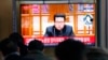 People watch a TV showing a file image of North Korean leader Kim Jong Un shown during a news program at the Seoul Railway Station in Seoul, South Korea, Jan. 20, 2022.