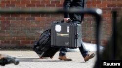 FILE - An inspector from the Organization for the Prohibition of Chemical Weapons (OPCW) arrives to begin work at the scene of the nerve agent attack on former Russian spy Sergei Skripal, in Salisbury, Britain, March 21, 2018. An OPCW team will begin coll