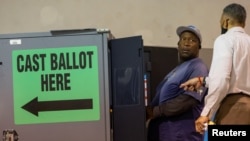 Seorang warga setempat memberikan suaranya menggunakan mesin Dominion Voting System dalam pemilihan paruh waktu di Calvary Baptist Church, Austell, Georgia, AS, 8 November 2022. REUTERS/Carlos Barria