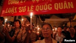 FILE - Protesters hold candles during a mass prayer for political dissident Le Quoc Quan at Thai Ha church in Hanoi June 30, 2013. 