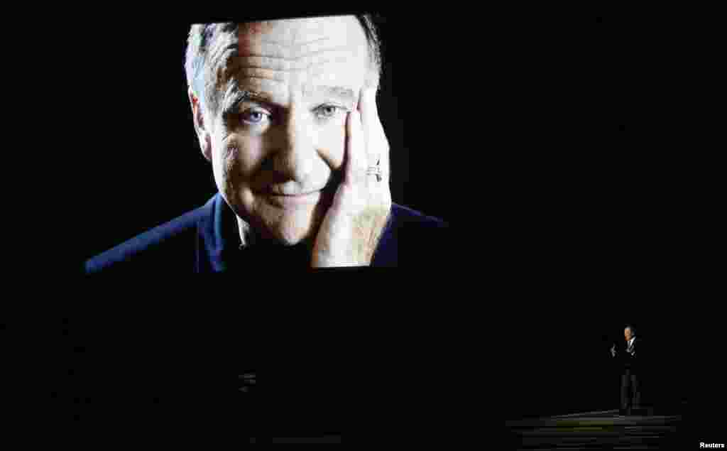 Billy Crystal pays tribute to the late Robin Williams, shown on a large screen, during the 66th Primetime Emmy Awards in Los Angeles, California, Aug. 25, 2014.