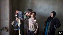 یک افسر ارتش عراق در روستای شورا پس از بیرون راندن نیروهای داعش بر سر پسری روستایی بوسه می زند